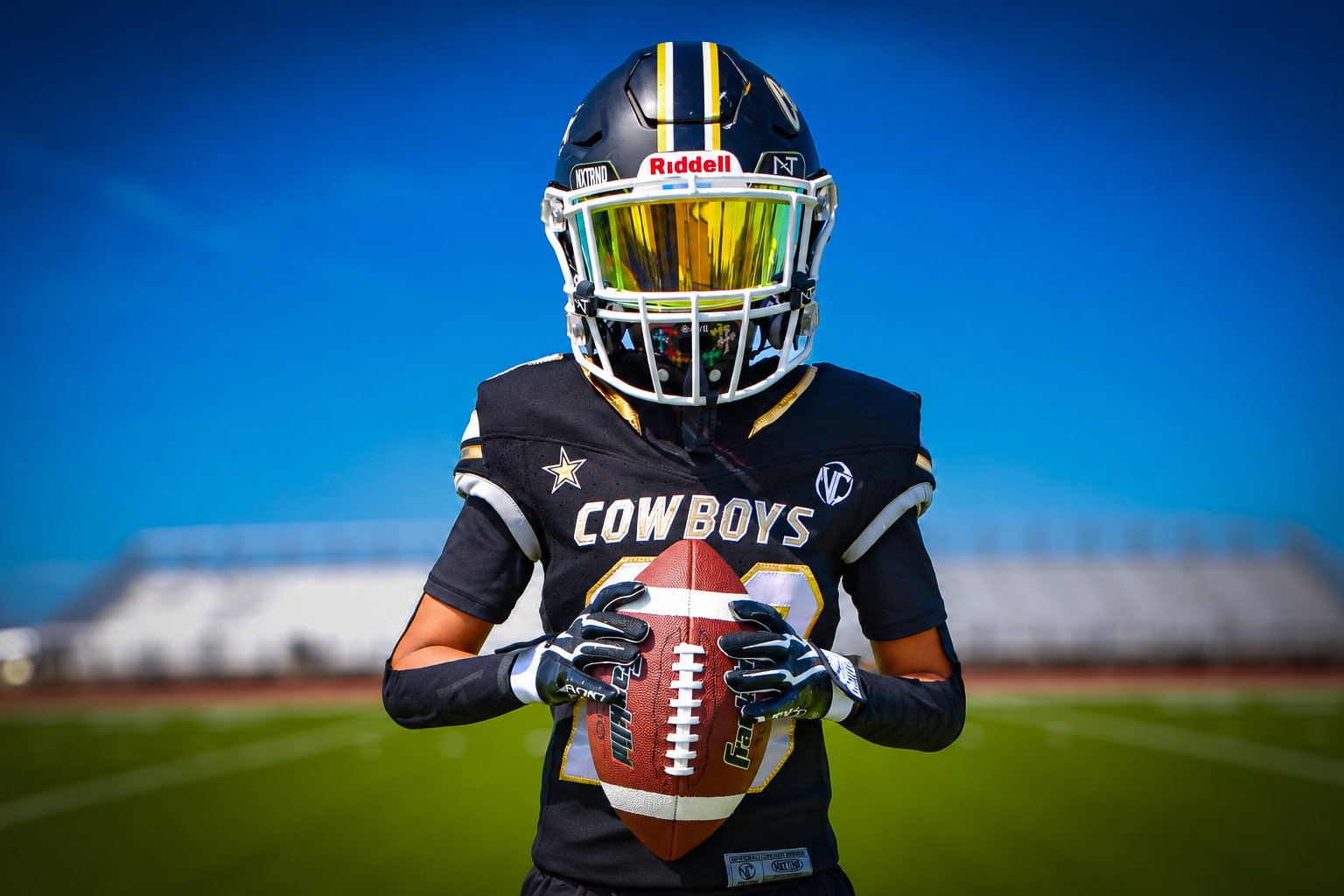NTX Cowboys player in a black-and-gold uniform holding a football